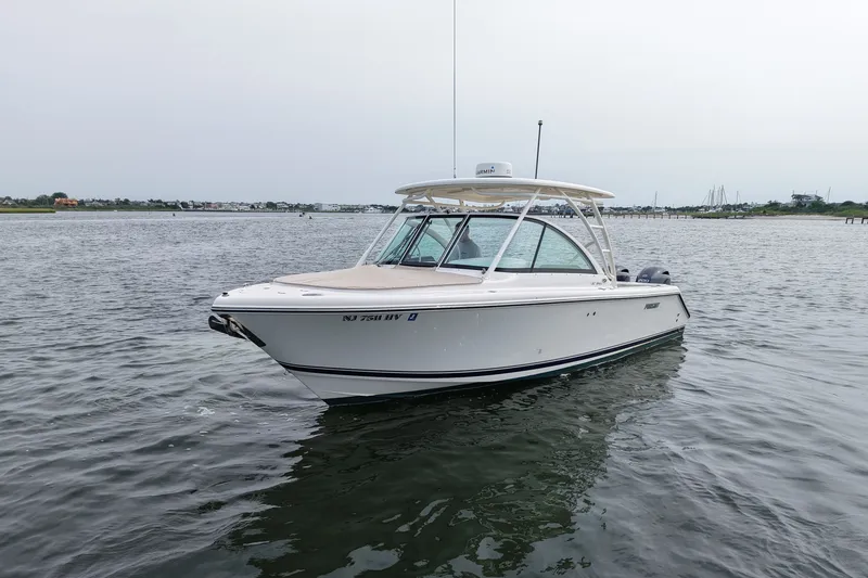 Slide: The Image of 2014 Pursuit DC 265 Dual Console boat on calm water, overcast sky. - 6