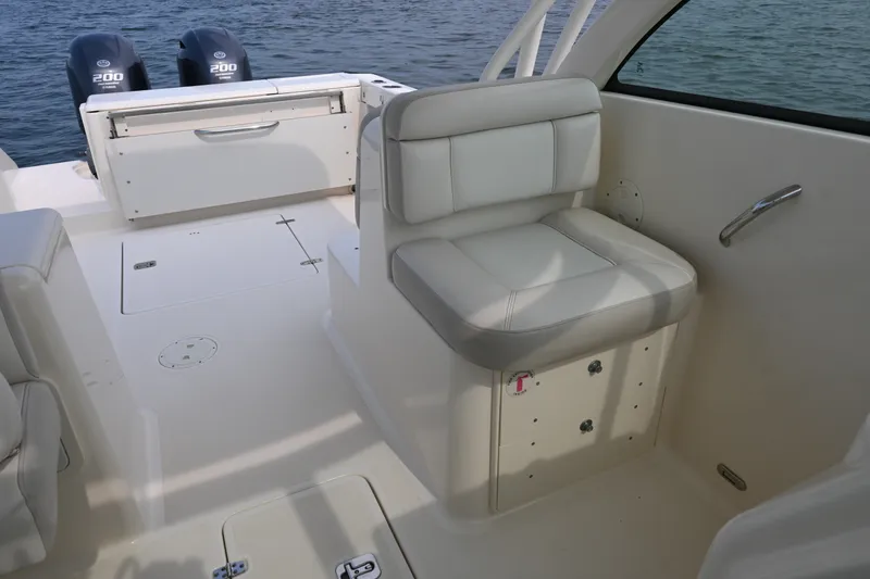 Slide: The Image of 2014 Pursuit DC 265 Dual Console boat interior with seating and twin engines. - 25