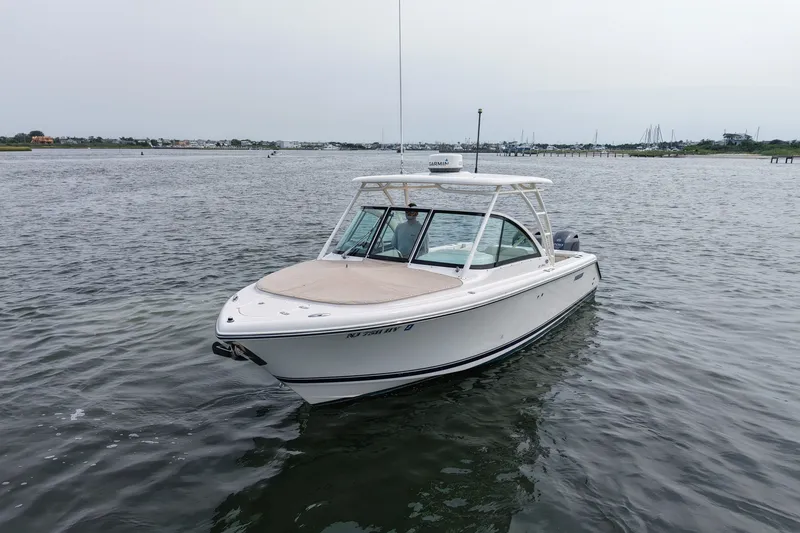Slide: The Image of 2014 Pursuit DC 265 Dual Console boat on calm water, overcast sky. - 7