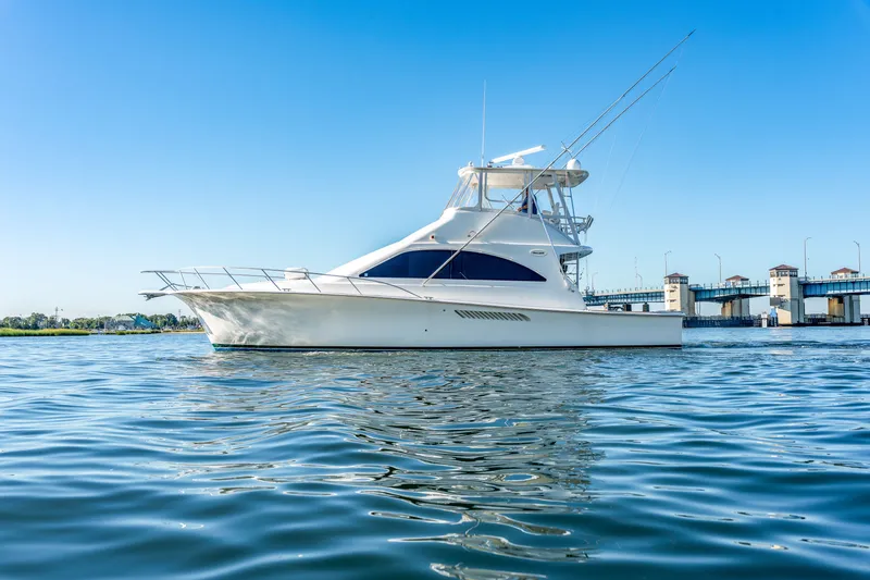 Slide: The Image of A white yacht with two decks on calm water, with a bridge in the background. - 17