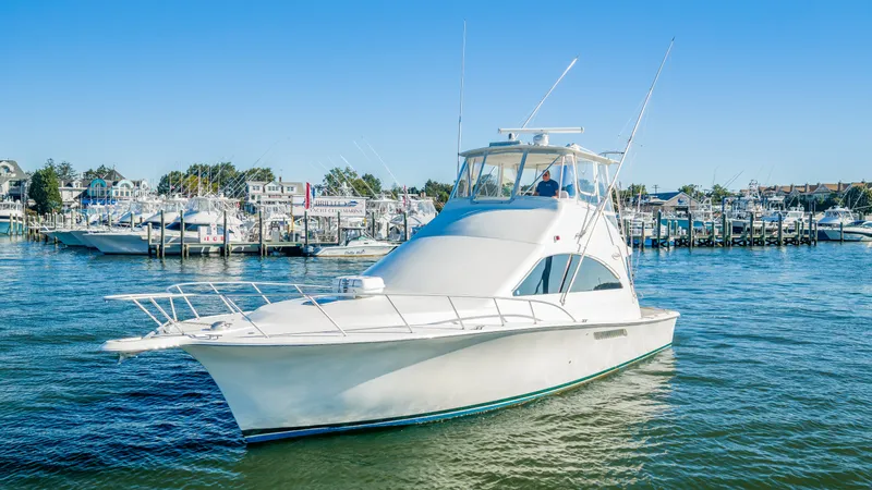 Slide: The Image of The 2007 Ocean Yachts 46 Super Sport is on the water near a marina. - 25