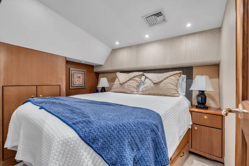 Slide: The Image of Luxurious bedroom with a large bed, blue and white bedding, and wooden furniture. - 33