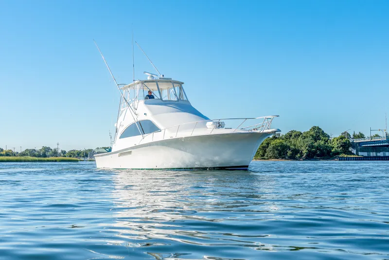 Slide: The Image of A white yacht calmly floating on the water, surrounded by green landscape. - 15