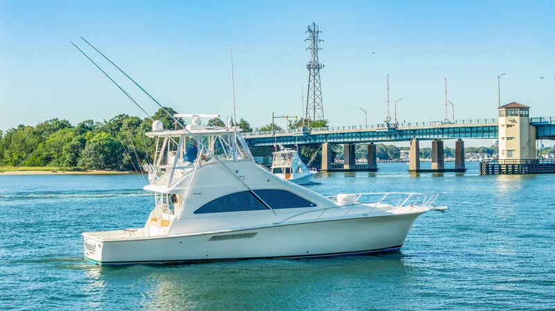 Slide: The Image of A white yacht cruising on a river, with a bridge in the background. - 20