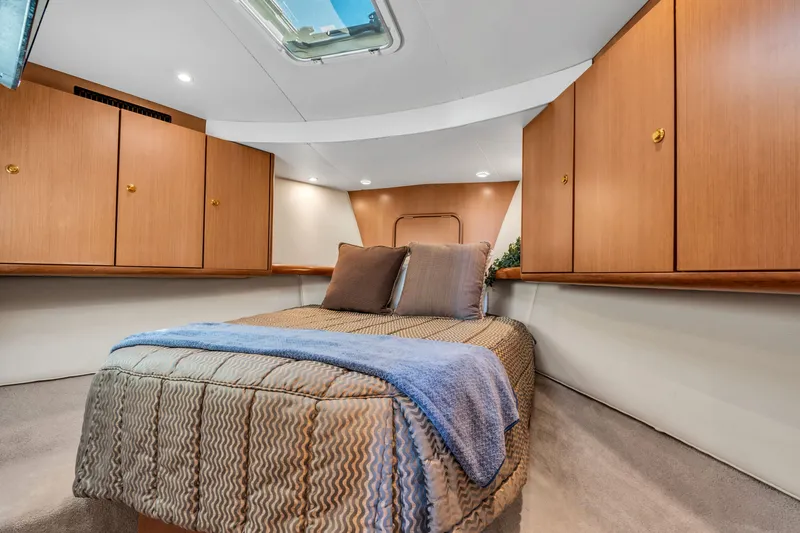 Slide: The Image of The cabin of a 2007 Ocean Yachts 46 Super Sport with a cozy bed and wooden cabinets. - 45