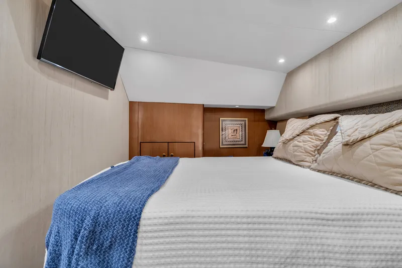 Slide: The Image of Cabin of the 2007 Ocean Yachts 46 Super Sport with double bed, blue blanket, and wall art. - 34