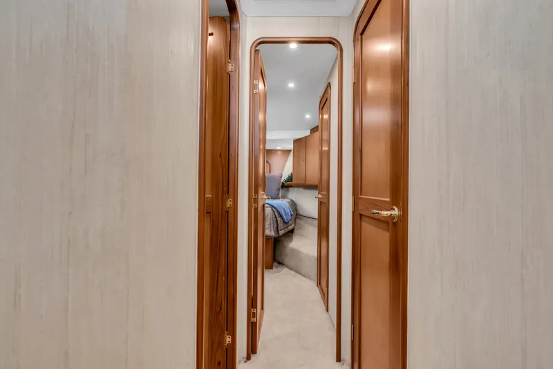 Slide: The Image of A sleek hallway with wooden doors leads to a cozy carpeted bedroom. - 38