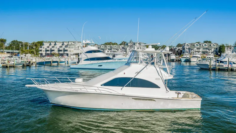 Slide: The Image of A white yacht is docked in a busy harbor with other boats in the background. - 24
