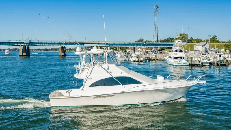 Slide: The Image of A 2007 Ocean Yachts 46 Super Sport cruising on a river, with a bridge in the background. - 19