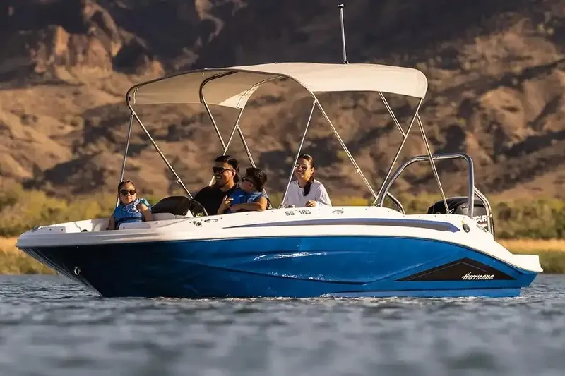Slide: The Image of Manufacturer Provided Image: 2026 Hurricane SunDeck Sport 185 OB boat cruising on a scenic lake with passengers. - 5