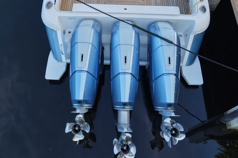 Slide: The Image of 2015 Intrepid 475 Panacea with triple outboard engines, docked on calm water. - 10