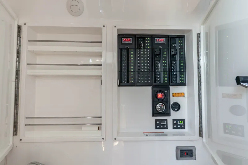 Slide: The Image of Electrical panel inside 2015 Intrepid 475 Panacea boat, featuring control switches and digital displays. - 16