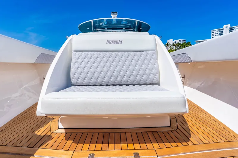 Slide: The Image of Luxurious seating on 2015 Intrepid 475 Panacea boat with teak deck and blue sky backdrop. - 12