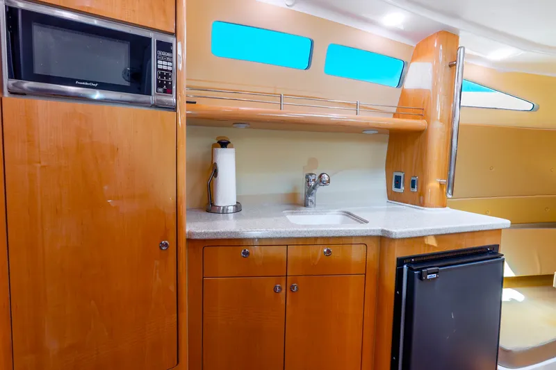 Slide: The Image of 2015 Intrepid 475 Panacea yacht kitchen with microwave, sink, and mini fridge. - 15