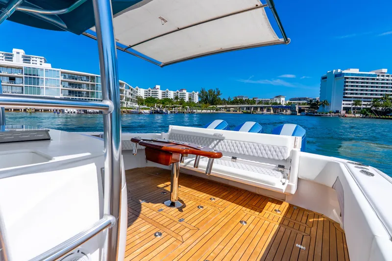 Slide: The Image of 2015 Intrepid 475 Panacea boat with teak deck, docked near waterfront buildings. - 23