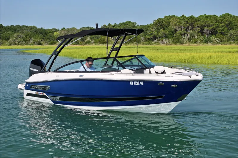 Slide: The Image of 2023 Monterey 235SS Super Sport boat cruising on a serene lake. - 2