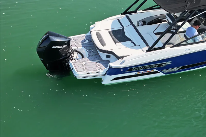 Slide: The Image of 2023 Monterey 235SS Super Sport boat with Mercury engine on green water. - 5