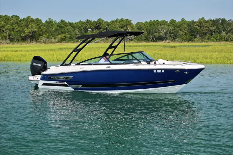 The Image of 2023 Monterey 235SS Super Sport boat on calm water, surrounded by lush greenery. - 0