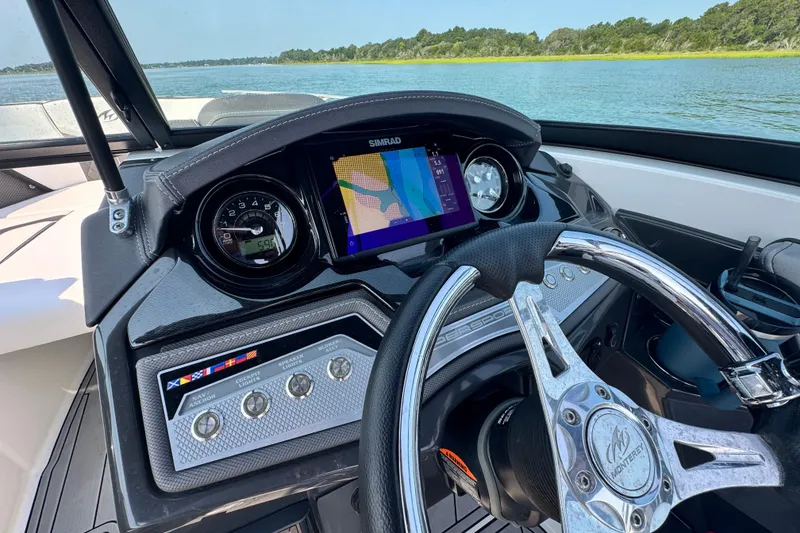 Slide: The Image of 2023 Monterey 235SS Super Sport dashboard with navigation display on a scenic lake. - 19