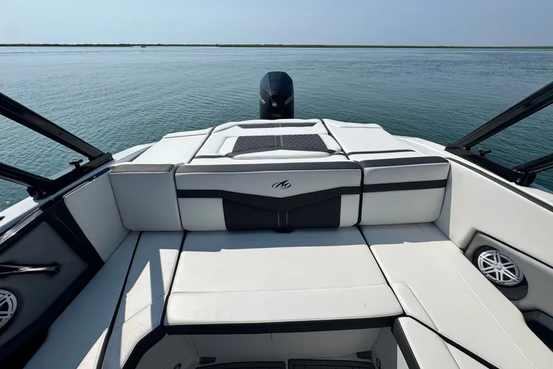 Slide: The Image of 2023 Monterey 235SS Super Sport boat interior with cushioned seating on calm water. - 15