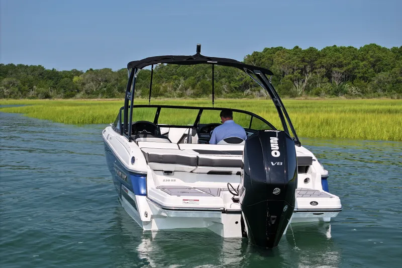 Slide: The Image of 2023 Monterey 235SS Super Sport boat cruising on a serene lake. - 4