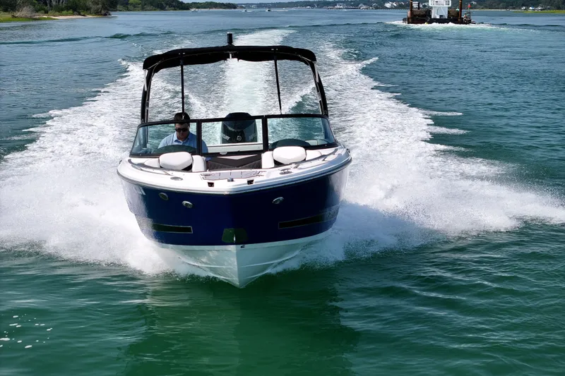 Slide: The Image of 2023 Monterey 235SS Super Sport boat cruising on clear blue water. - 6