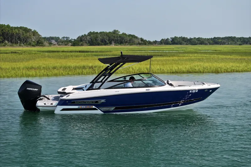Slide: The Image of 2023 Monterey 235SS Super Sport boat cruising on a serene lake. - 1