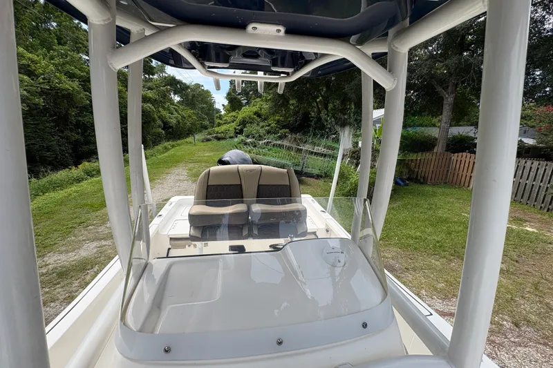 Slide: The Image of 2019 Tidewater 2200 Carolina Bay boat with seating and console, parked on a grassy path. - 29