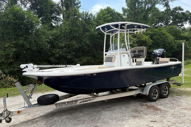 The Image of 2019 Tidewater 2200 Carolina Bay boat on trailer, surrounded by lush greenery. - 0