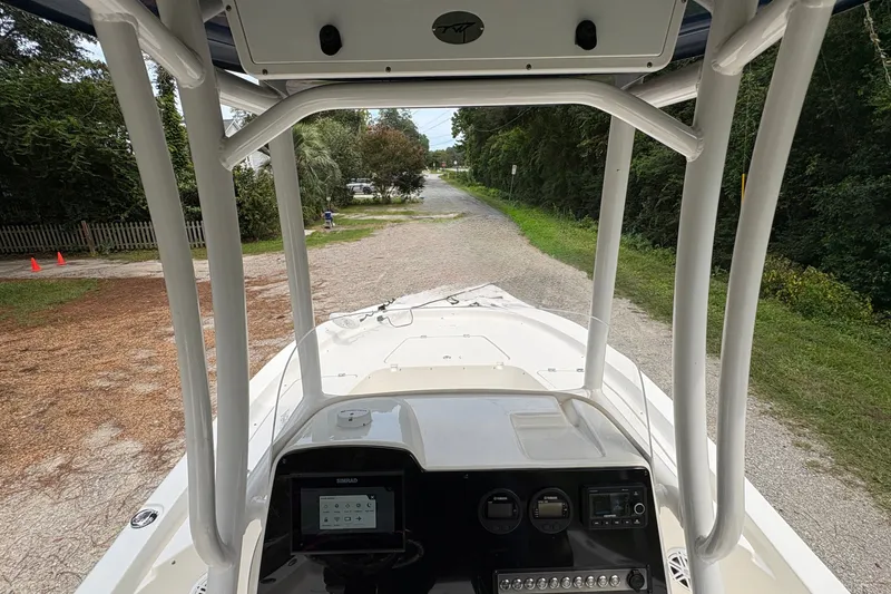 Slide: The Image of 2019 Tidewater 2200 Carolina Bay boat interior with navigation console, parked on a gravel path. - 19