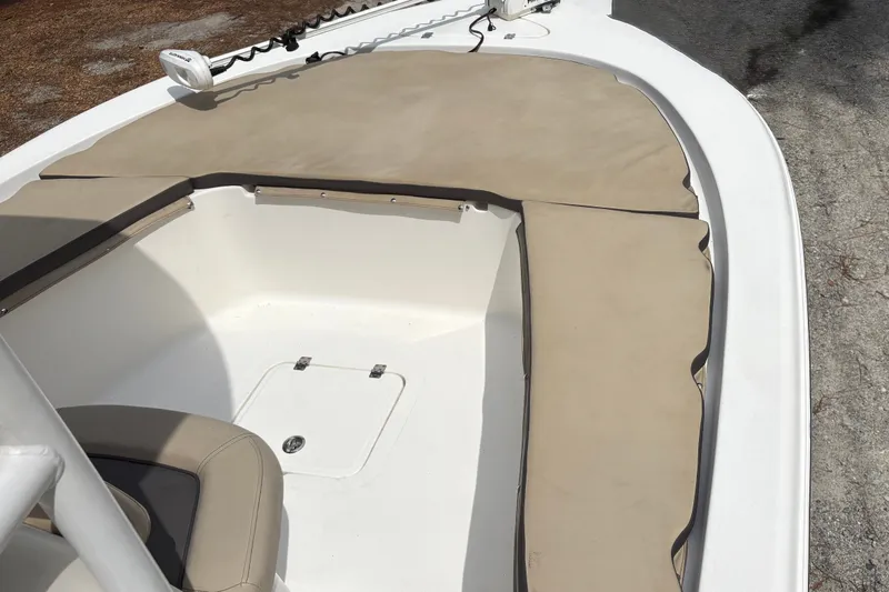 Slide: The Image of 2019 Tidewater 2200 Carolina Bay boat interior with beige seating and storage compartment. - 13