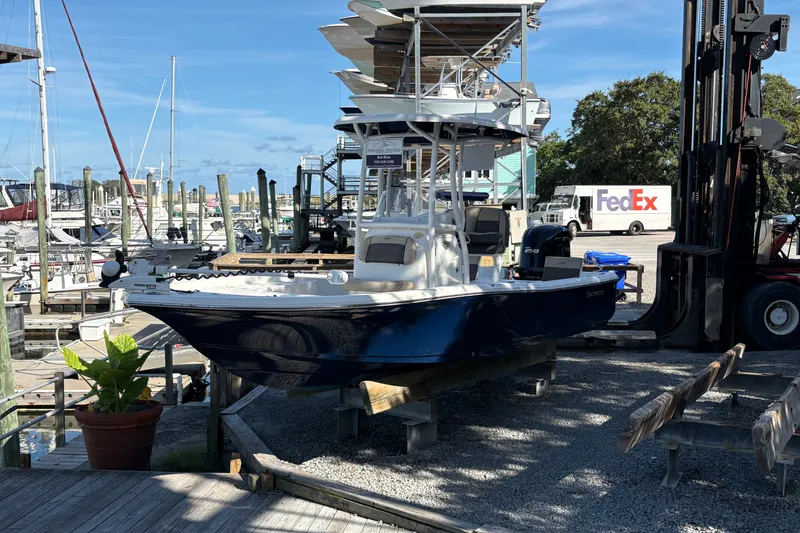 Slide: The Image of 2019 Tidewater 2200 Carolina Bay boat at marina, surrounded by docks and a FedEx truck. - 11