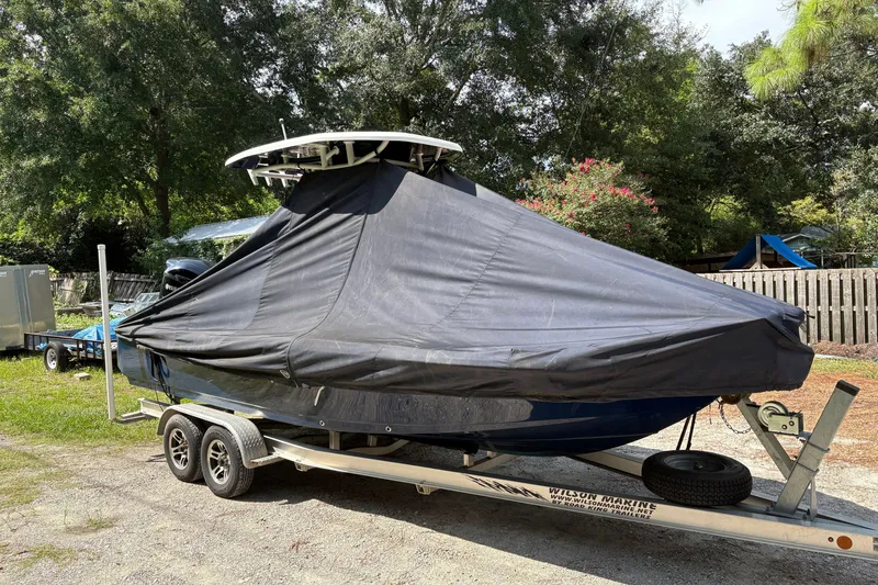 Slide: The Image of 2019 Tidewater 2200 Carolina Bay boat covered on trailer in a yard. - 45