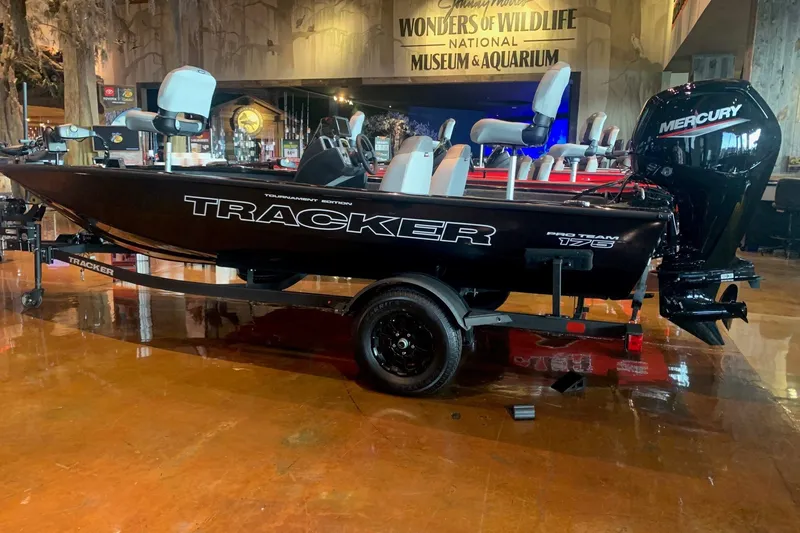 The Image of 2027 Tracker Pro Team 175 boat displayed indoors at a museum, featuring a Mercury engine. - 0