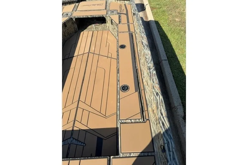 Slide: The Image of 2027 Tracker Grizzly 1756 T Marsh boat deck with camouflage design and storage compartments. - 14
