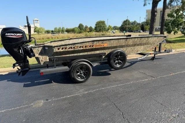 The Image of 2027 Tracker Grizzly 1756 T Marsh boat on trailer with Mercury engine, parked outdoors. - 0
