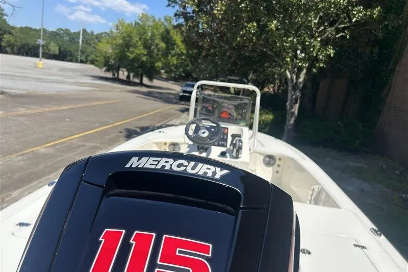 Slide: The Image of 2026 Mako 18 Pro Skiff with Mercury 115 engine in a parking lot. - 3