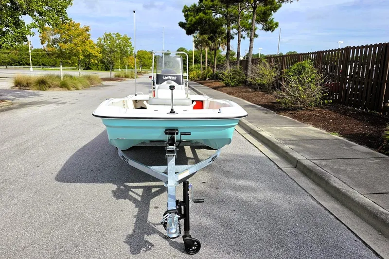 Slide: The Image of 2026 Mako Pro Skiff 15 CC boat on trailer, parked on a sunny street. - 6