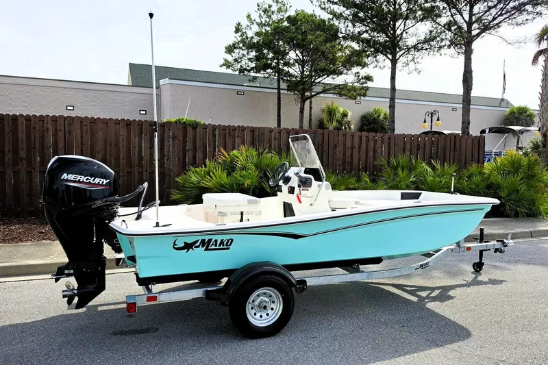 Slide: The Image of 2026 Mako Pro Skiff 15 CC boat on trailer, parked outdoors. - 1