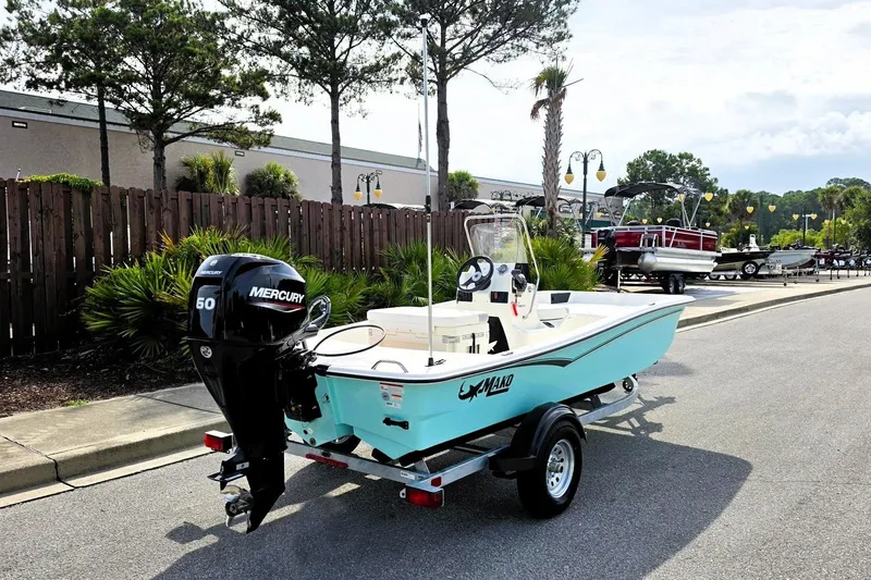 Slide: The Image of 2026 Mako Pro Skiff 15 CC boat with Mercury 50 engine on trailer, parked outdoors. - 3