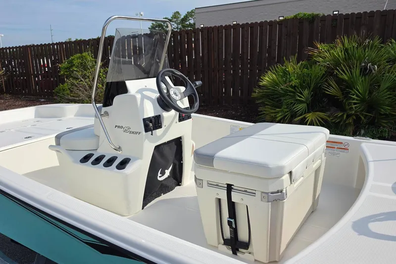 Slide: The Image of 2026 Mako Pro Skiff 15 CC boat interior with steering console and cushioned seating. - 16