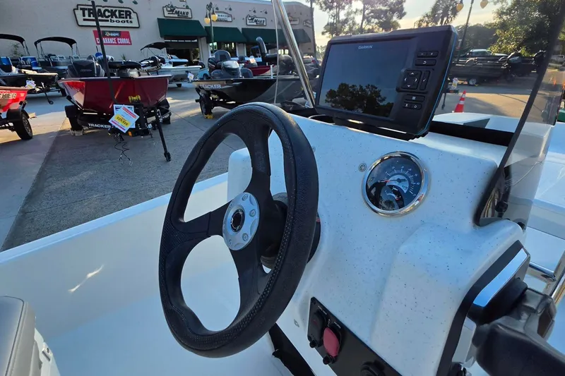Slide: The Image of 2026 Mako Pro Skiff 15 CC dashboard with steering wheel and navigation display. - 17
