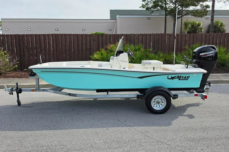 Slide: The Image of 2026 Mako Pro Skiff 15 CC boat on trailer, featuring a sleek design and Mercury outboard motor. - 10