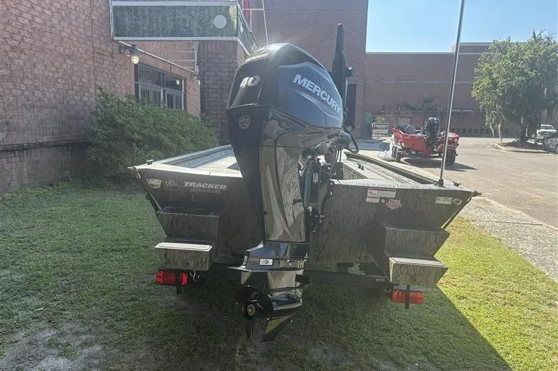 Slide: The Image of 2027 Tracker Grizzly 1654 T Sportsman boat with Mercury engine, parked outdoors. - 13