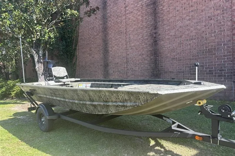 The Image of 2027 Tracker Grizzly 1654 T Sportsman boat on trailer, parked outdoors. - 0