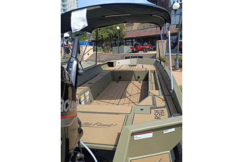 The Image of 2027 Tracker Grizzly 1756 T Marsh boat with spacious deck and canopy in urban setting. - 0