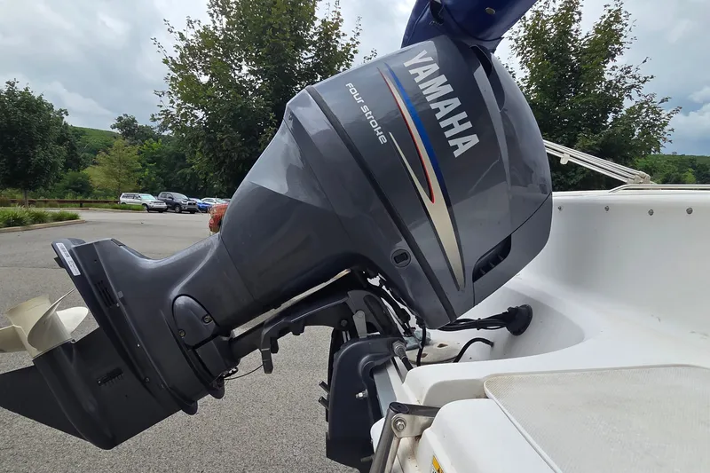 Slide: The Image of Yamaha outboard motor on 2011 Hurricane SunDeck Sport 188 OB boat, parked outdoors. - 2