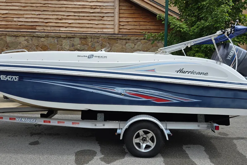 Slide: The Image of 2011 Hurricane SunDeck Sport 188 OB boat on trailer, parked outdoors. - 10