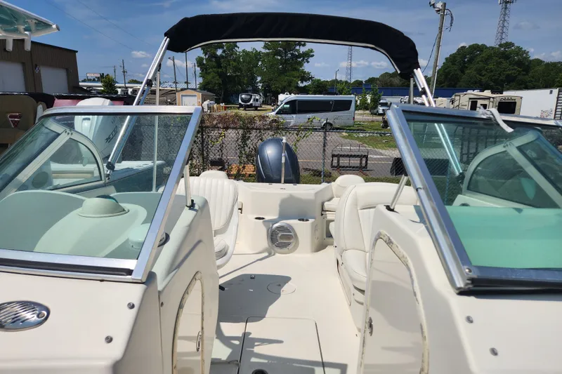 Slide: The Image of 2004 Hydra-Sports Lightning 202 DC boat interior with seating and windshield, parked outdoors. - 12