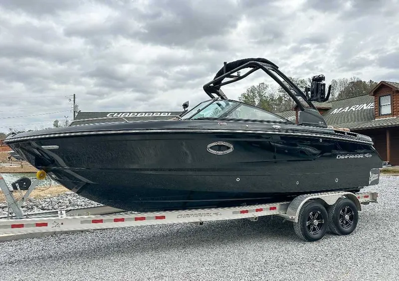 The Image of A black 2026 Chaparral GTS 6 boat on a trailer in a gravel lot. - 1